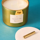 Green candle with gold lid on a blue background