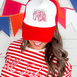 Person wearing a red and white cap with an elephant design and a red and white striped shirt with text.