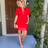 Woman in a red dress standing on a porch