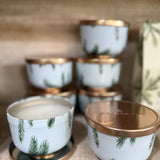 Set of small ceramic containers with gold lids on a textured surface