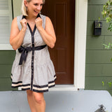 Woman in a striped dress standing on a porch
