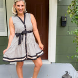 Woman in a striped dress standing outside a house