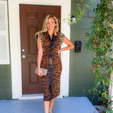 Woman in a tiger print dress standing on a porch