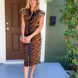 Woman in a tiger print dress standing on a porch