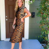 Woman in a tiger print dress standing on a porch