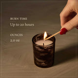 Candle being lit with text about burn time and size on a wooden surface
