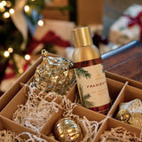 Frasier bottle in a decorative box with Christmas ornaments and lights in the background