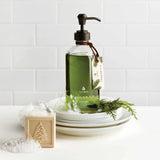 Green bottle with pump dispenser on a white surface with decorative elements