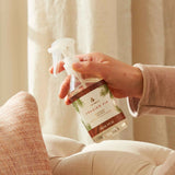 Hand holding a 'Frasier Fir' room spray bottle with a neutral background