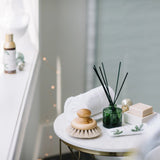 Table with cleaning tools and decorative items in a bathroom setting