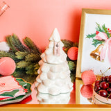 White ceramic Christmas tree ornament on a decorative table with pink background