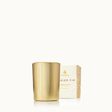 Gold candle and its packaging on a white background