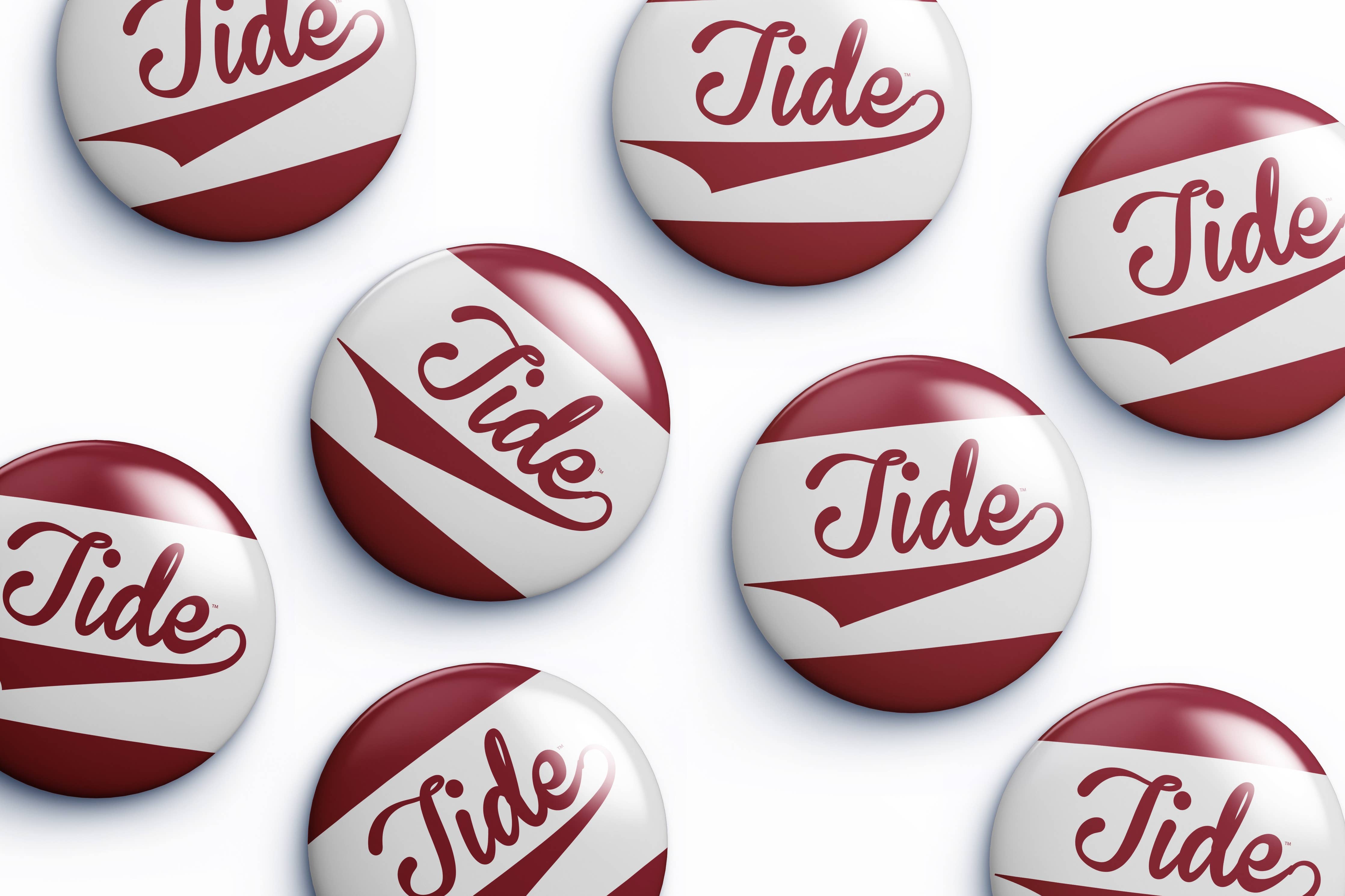 Several round button badges with the word Tide in red script over a white and dark red striped design, arranged on a light gray background.