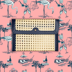 Woven clutch bag on a pink background with vintage-style illustrations