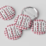 Five round pinback buttons with a red and white gingham pattern and the text 'RTR' in bold white letters outlined in black, shown on a light gray background. One button is turned over to show the metal pin back.