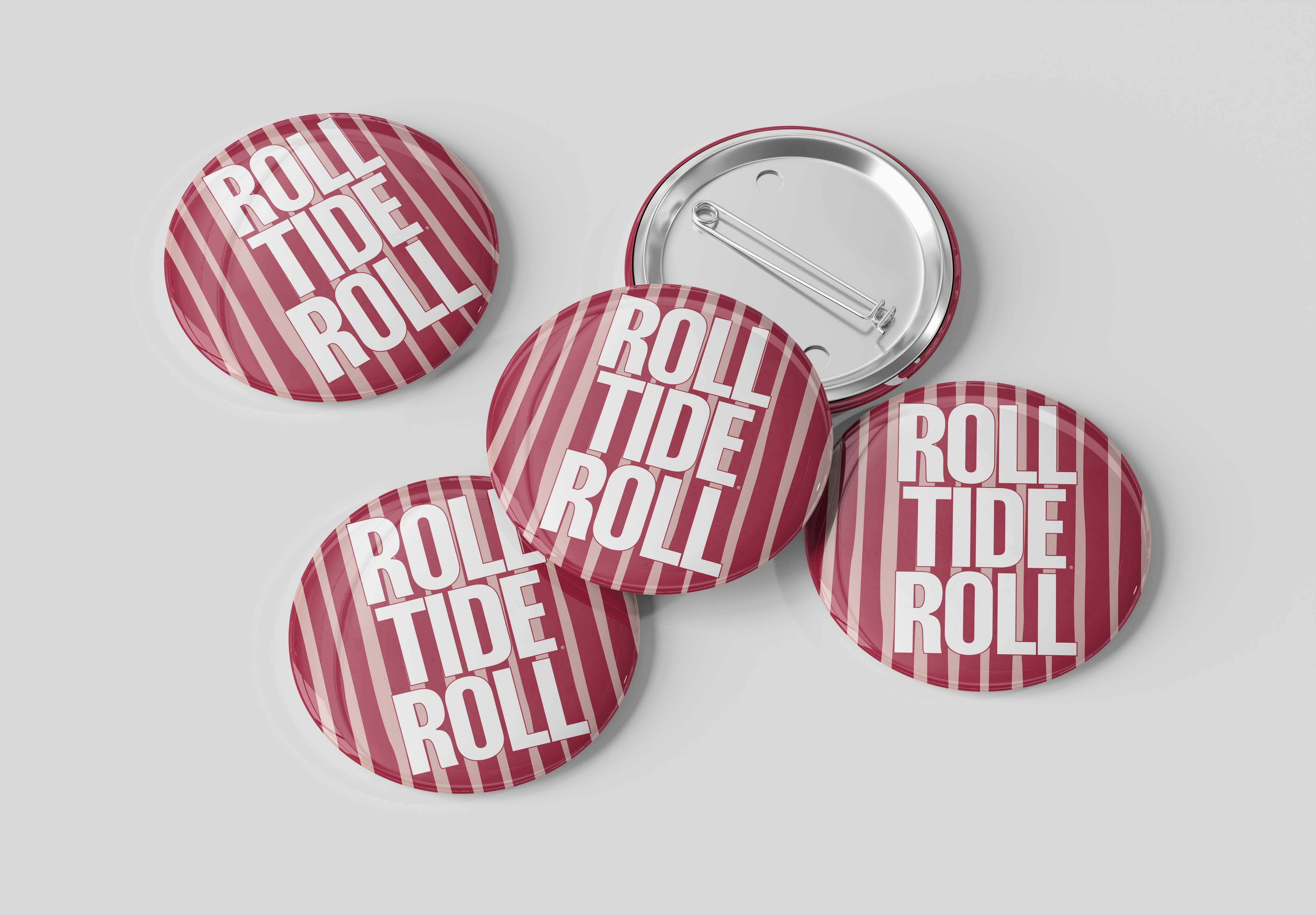 Five round pin-back buttons with a red and white striped pattern and the text 'ROLL TIDE ROLL' in white, with one button showing the silver metal back, on a light gray background.