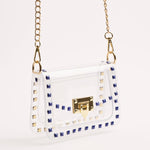 White handbag with gold accents and blue stud details on a white background