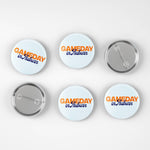 Six round pin-back buttons shown on a light gray background, including three front views and three back views. The front buttons have a white background with orange and blue text reading 'GAMEDAY in Auburn'.
