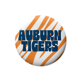 A circular button badge featuring the Auburn Tigers logo, with orange and white diagonal stripes and bold blue text reading 'AUBURN TIGERS' on a white background.