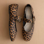 Leopard print shoes with buckles on a beige background