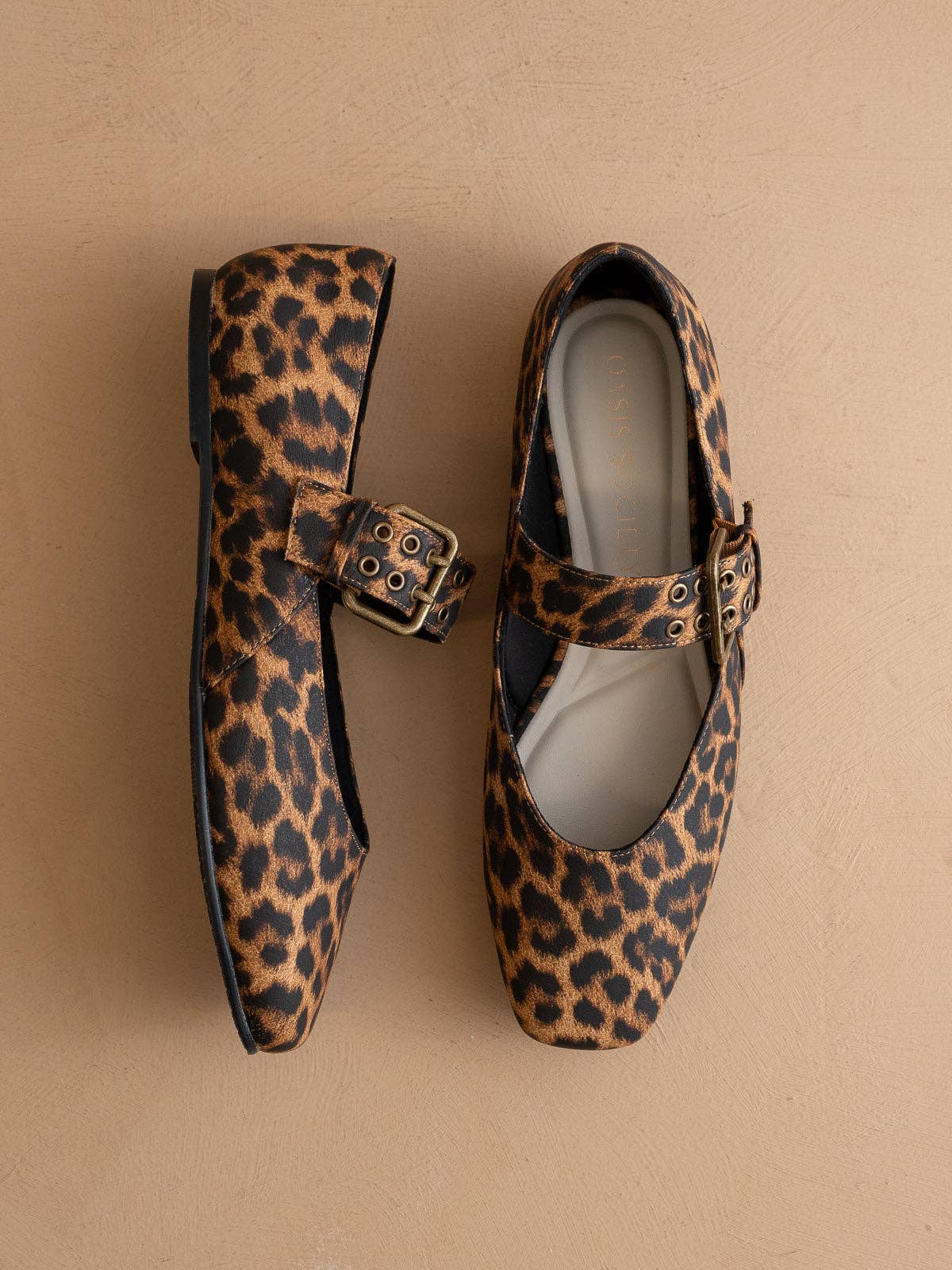 Leopard print shoes with buckles on a beige background