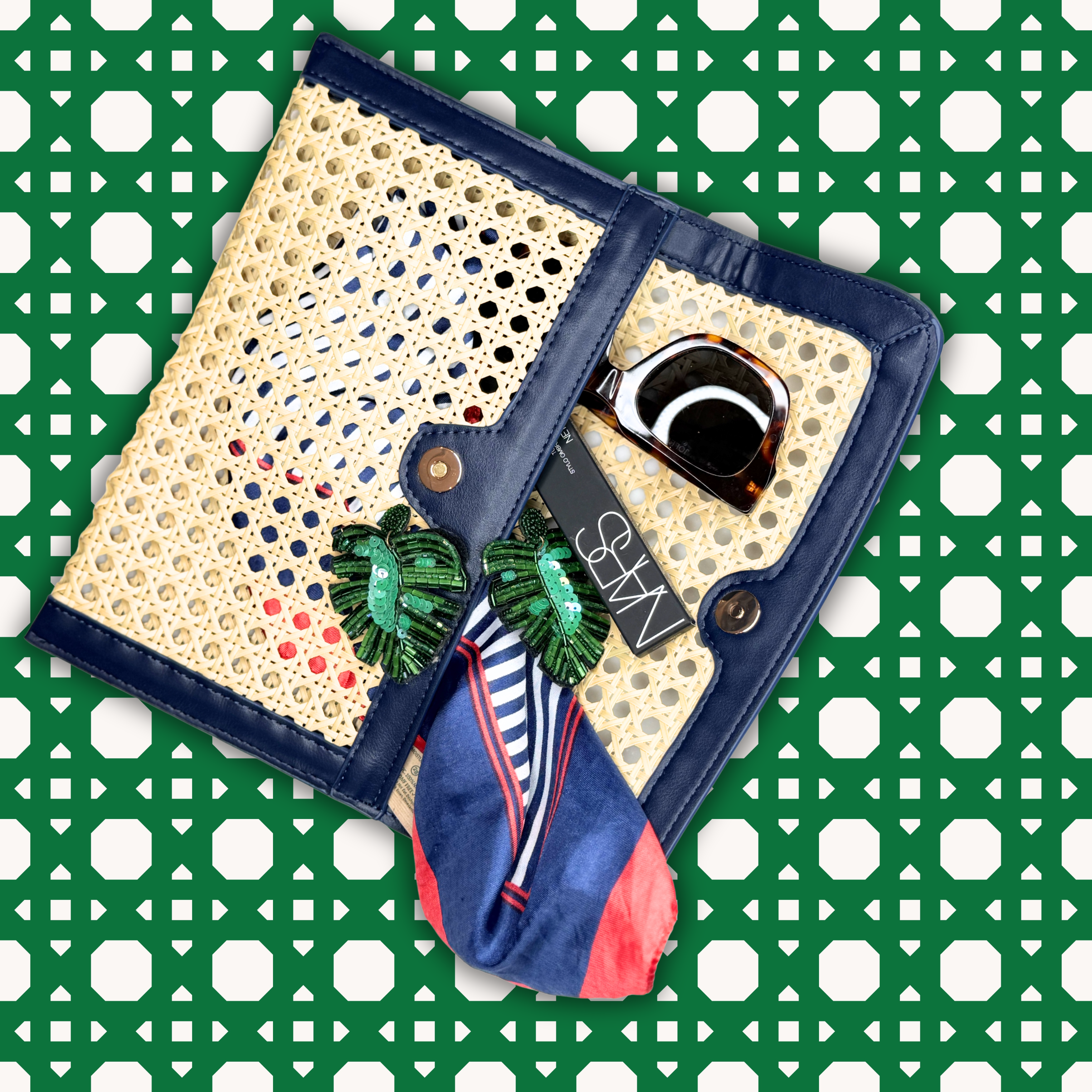 Decorative clutch with a watch, earrings, and a scarf on a green and white patterned background