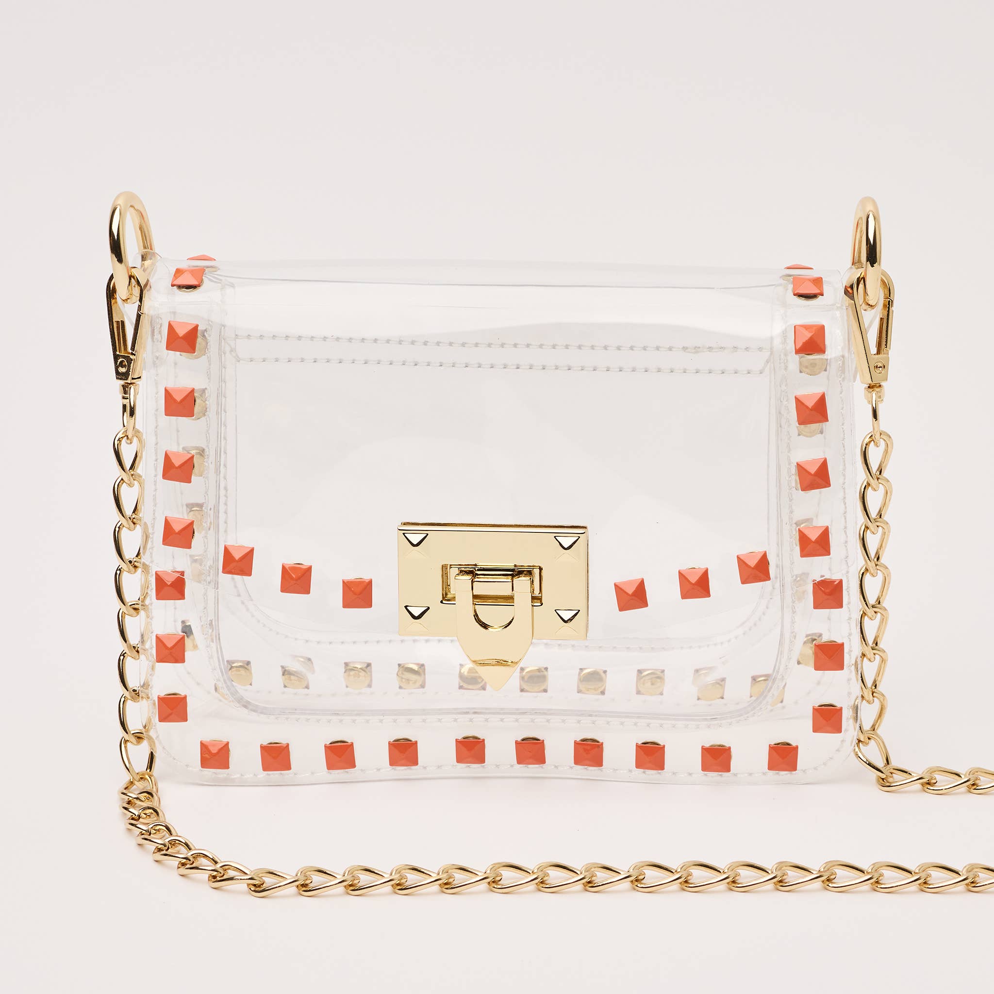 White handbag with gold chain strap and red studded details on a light gray background
