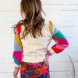 Person wearing a colorful sweater with a white background