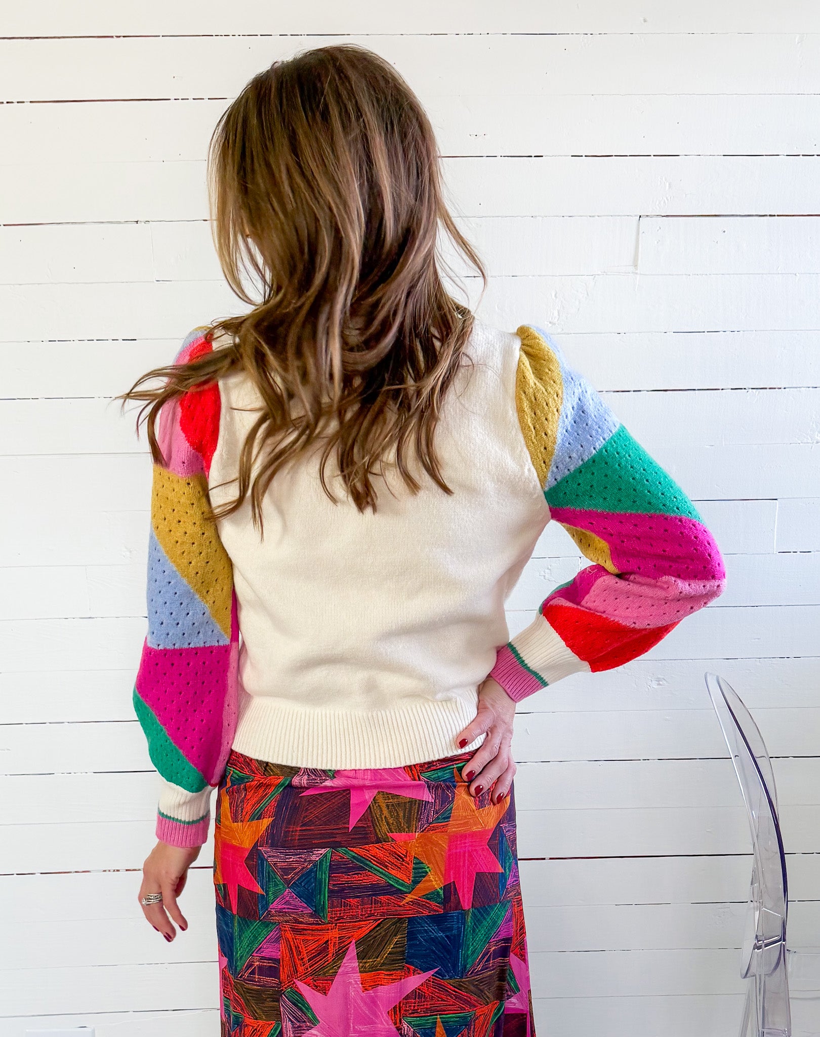 Person wearing a colorful sweater with a white background