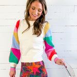 Woman wearing a colorful sweater with a white background