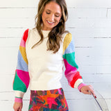 Woman wearing a colorful sweater with a white background