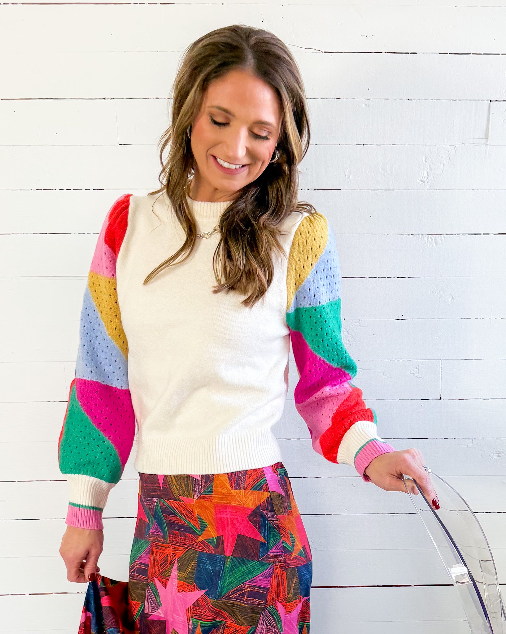 Woman wearing a colorful sweater with a white background