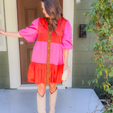 Woman in a two-tone dress standing on a porch
