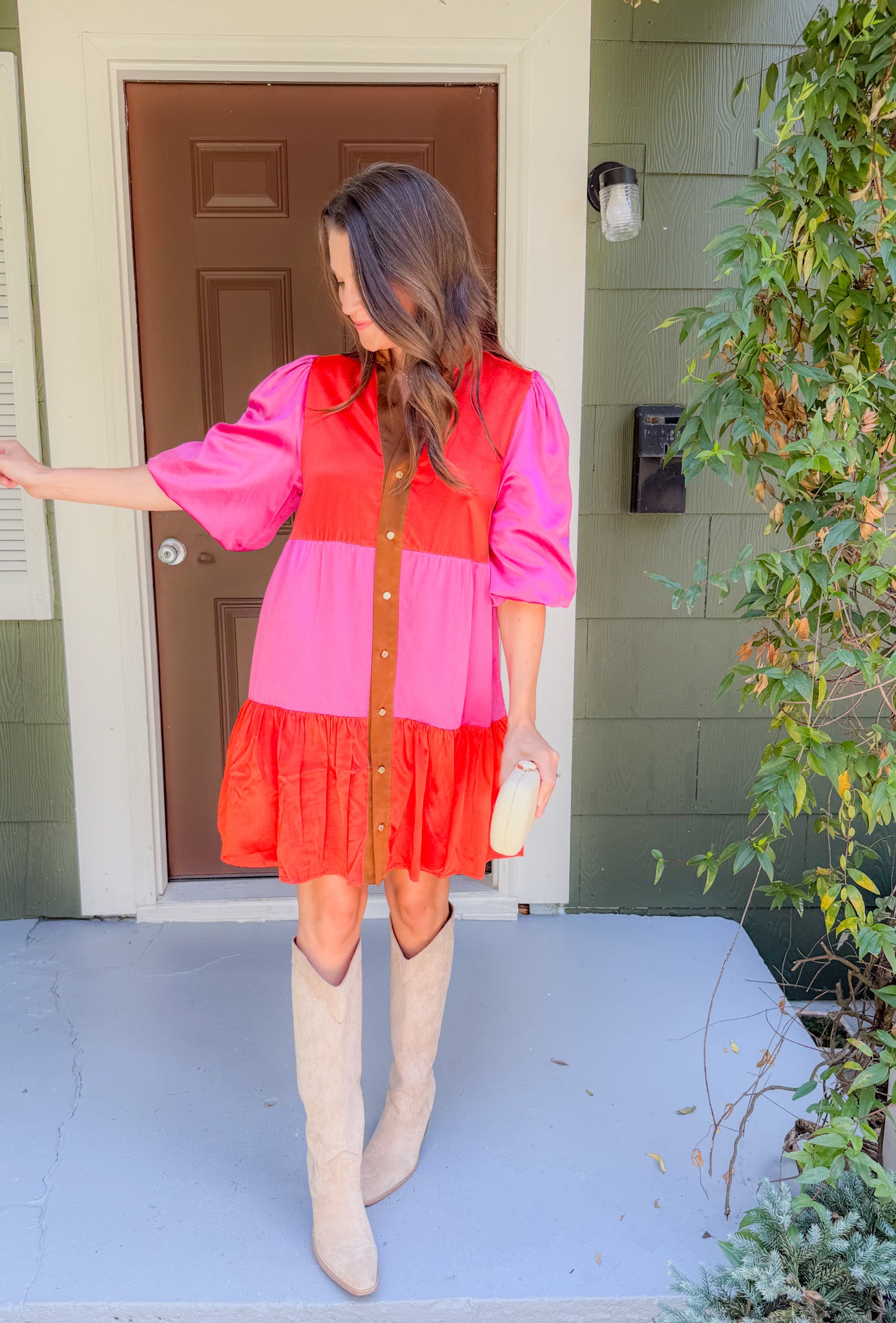 Woman in a two-tone dress standing on a porch
