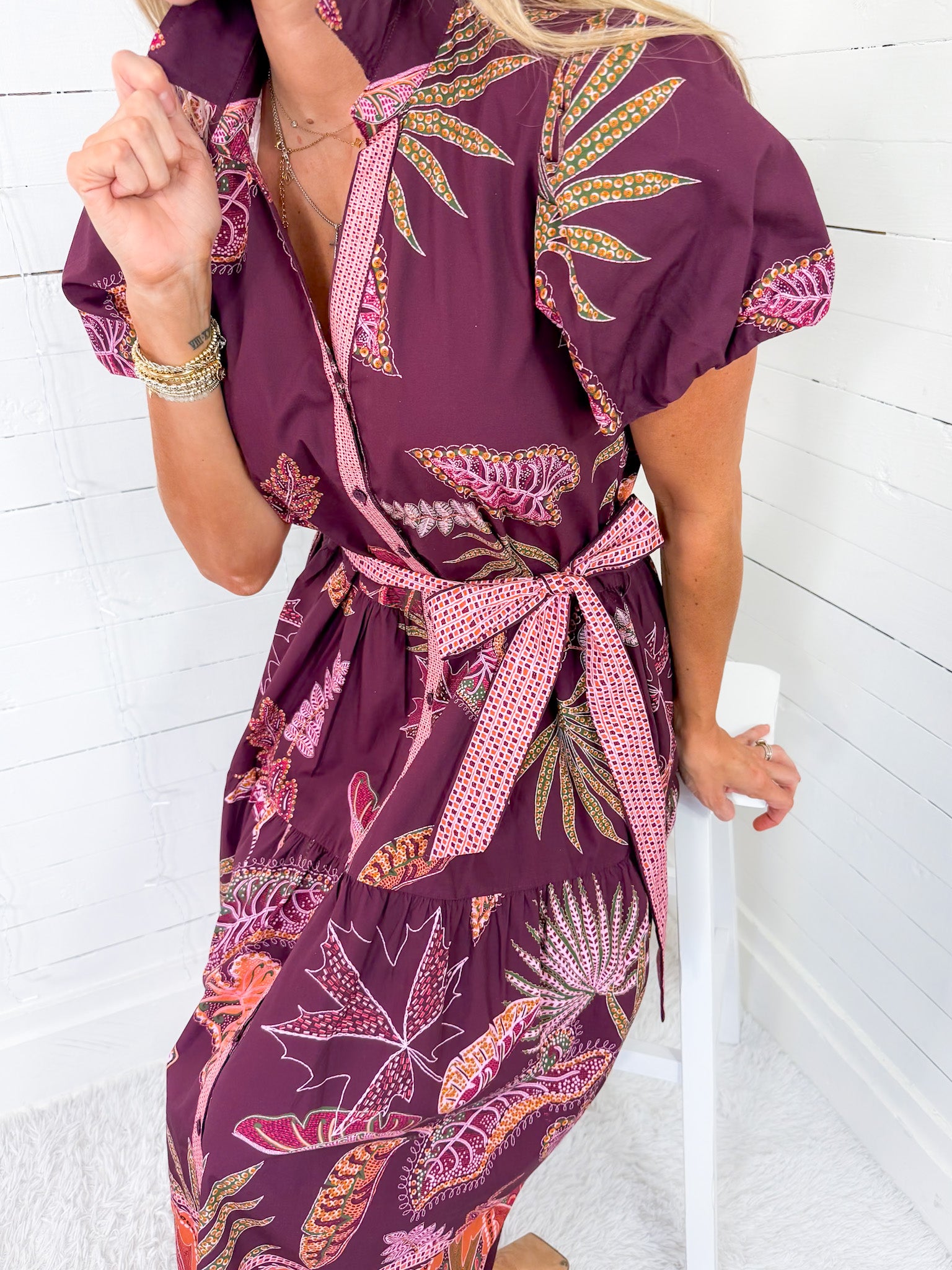 Woman wearing a purple floral dress with a white background