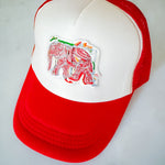 Red and white cap with an embroidered elephant design on a light gray background