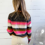 Person wearing a colorful striped sweater with a white background