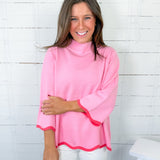 Woman wearing a pink long-sleeve top with a white background
