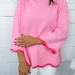 Person wearing a pink long-sleeve top with a white background