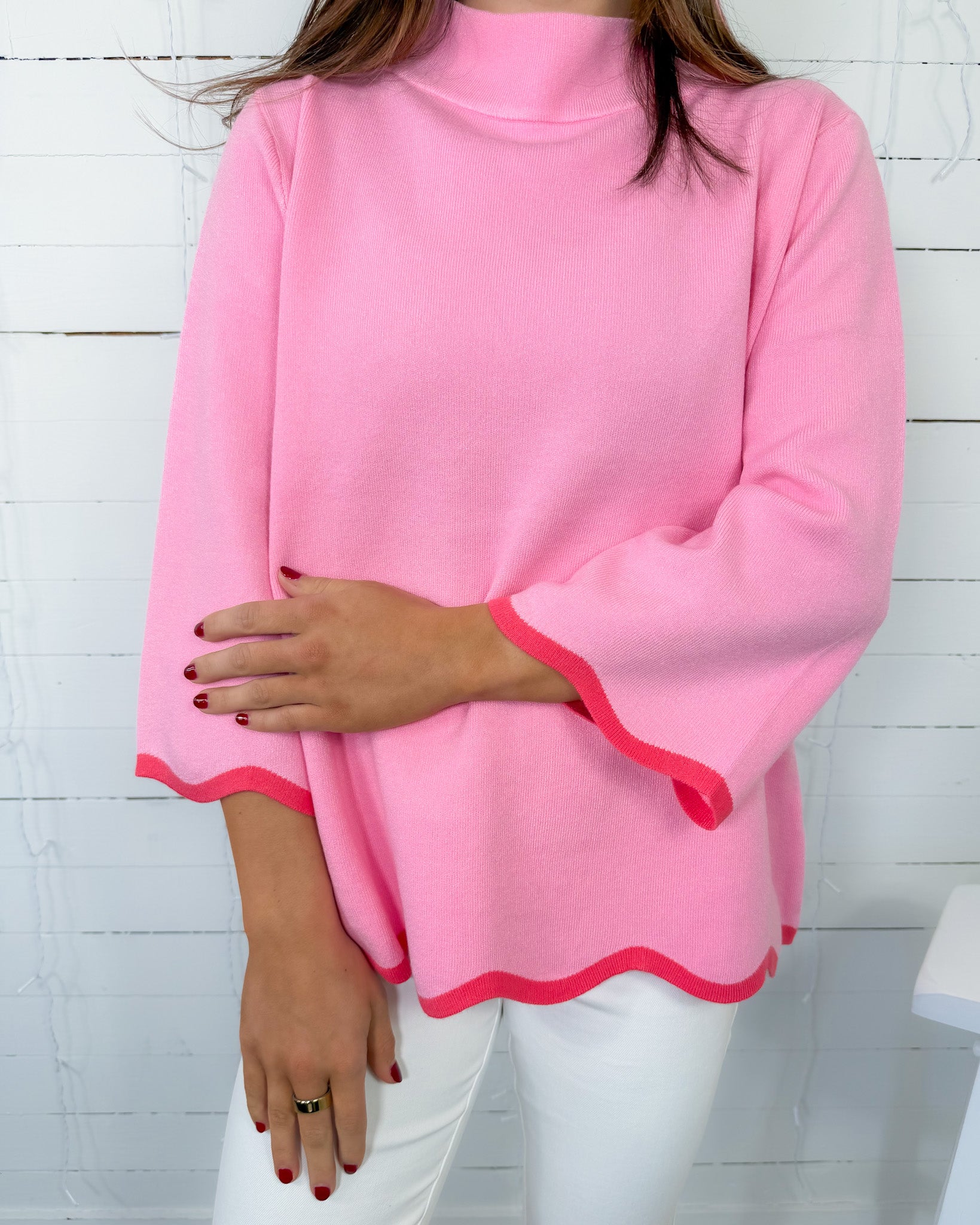 Person wearing a pink long-sleeve top with a white background