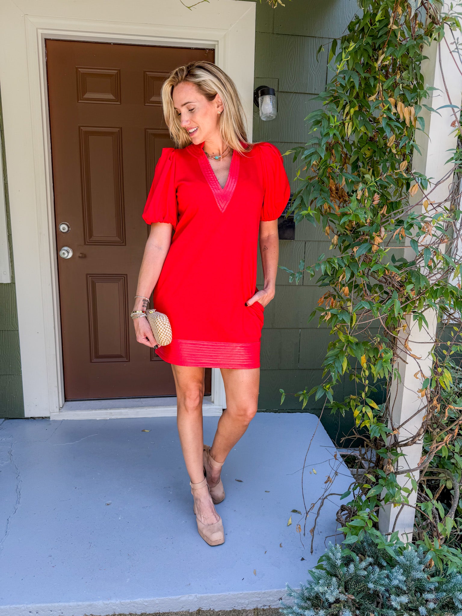 Woman in a red dress standing on a porch