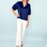 Model wearing navy shirt, white jeans and silver sandals