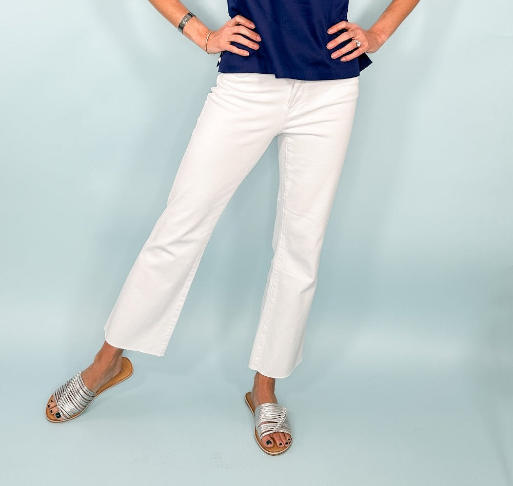 Model wearing navy shirt, white jeans and silver sandals