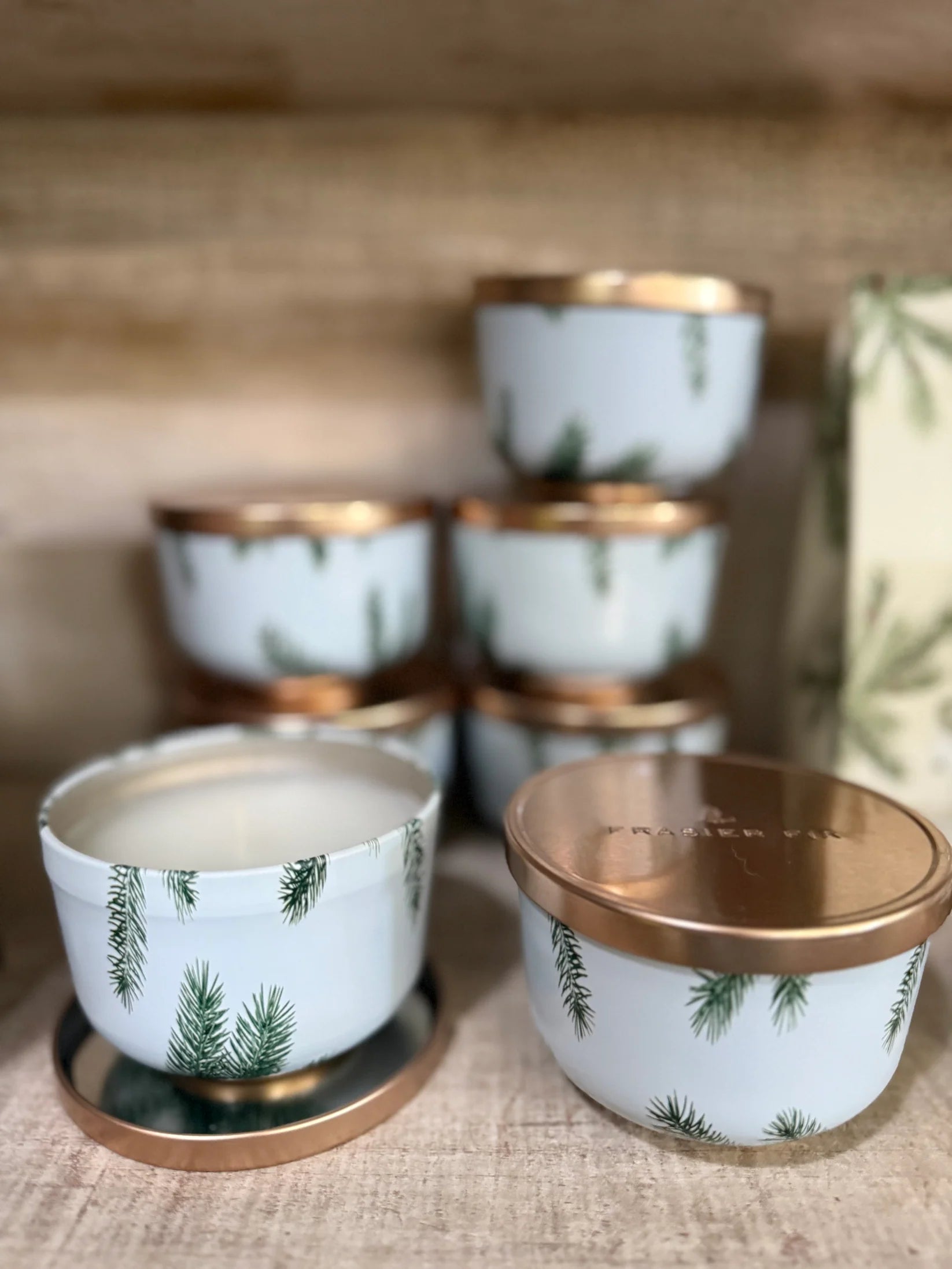 Set of small ceramic containers with gold lids on a textured surface