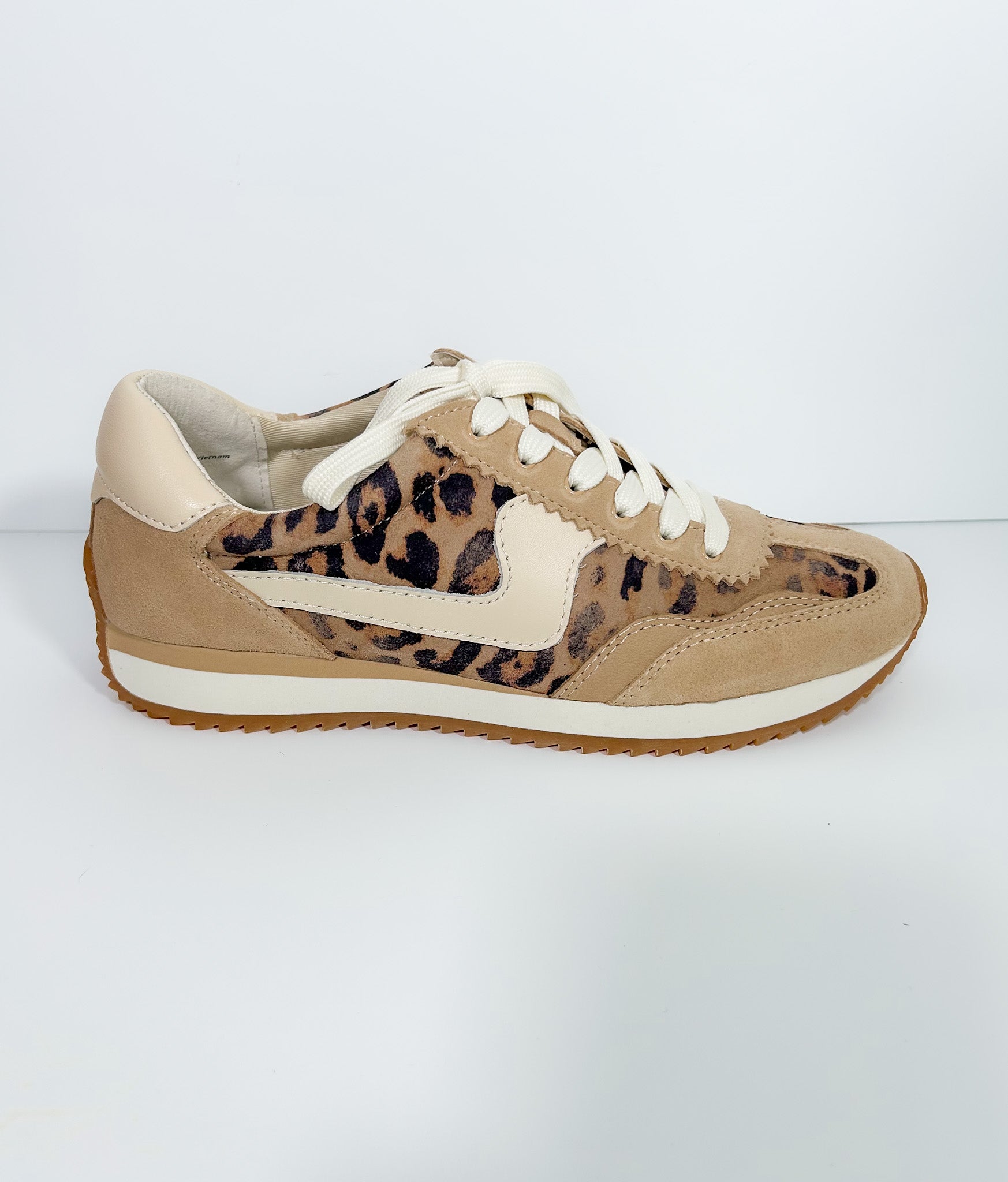 Beige sneaker with leopard print accents on a white background