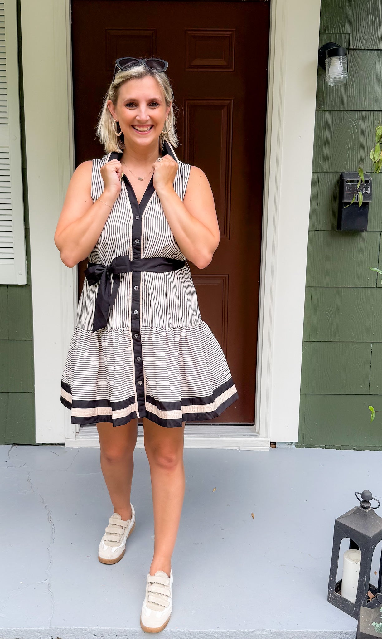 Woman in a striped dress standing on a porch