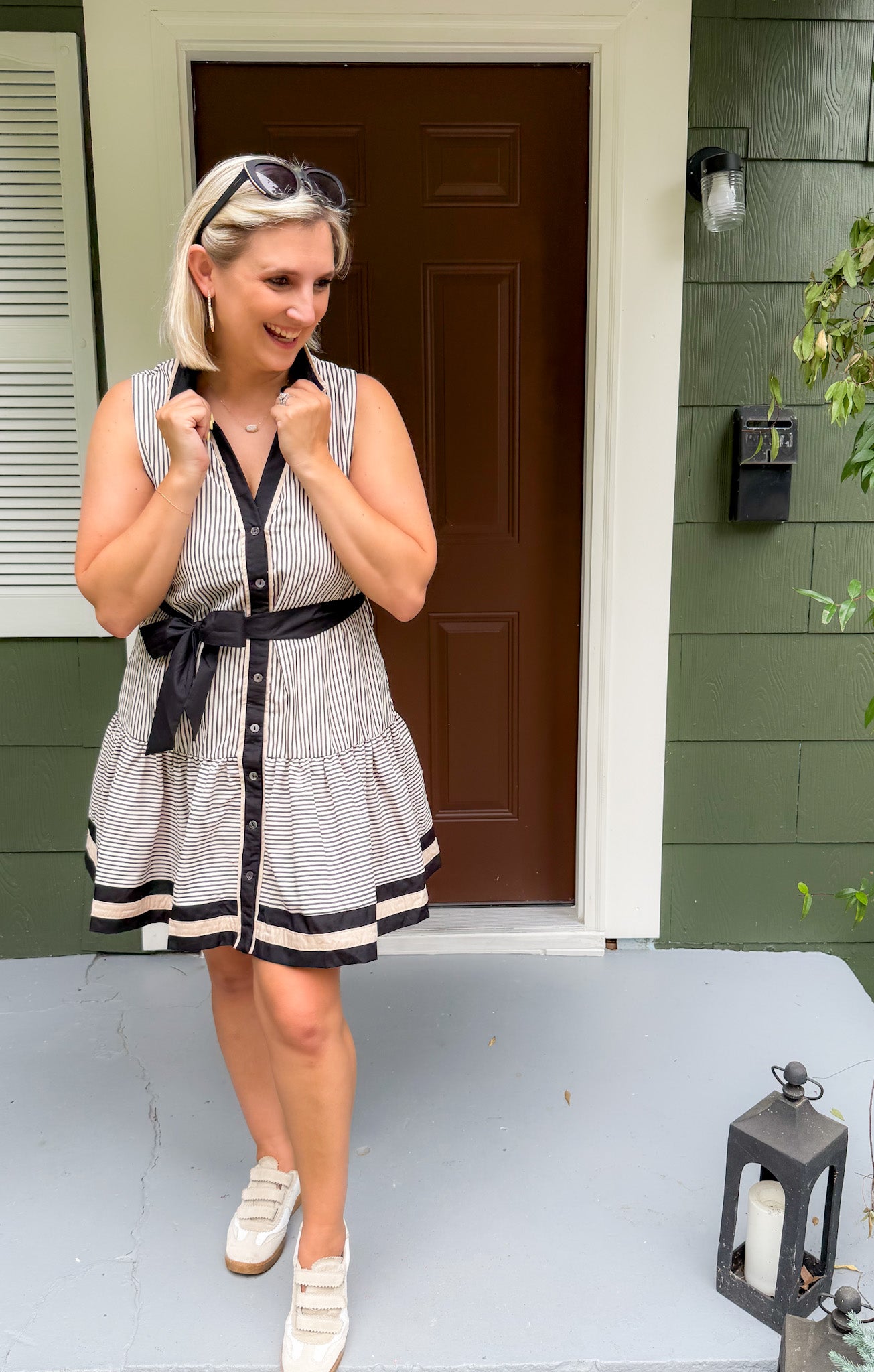 Woman in a striped dress standing on a porch