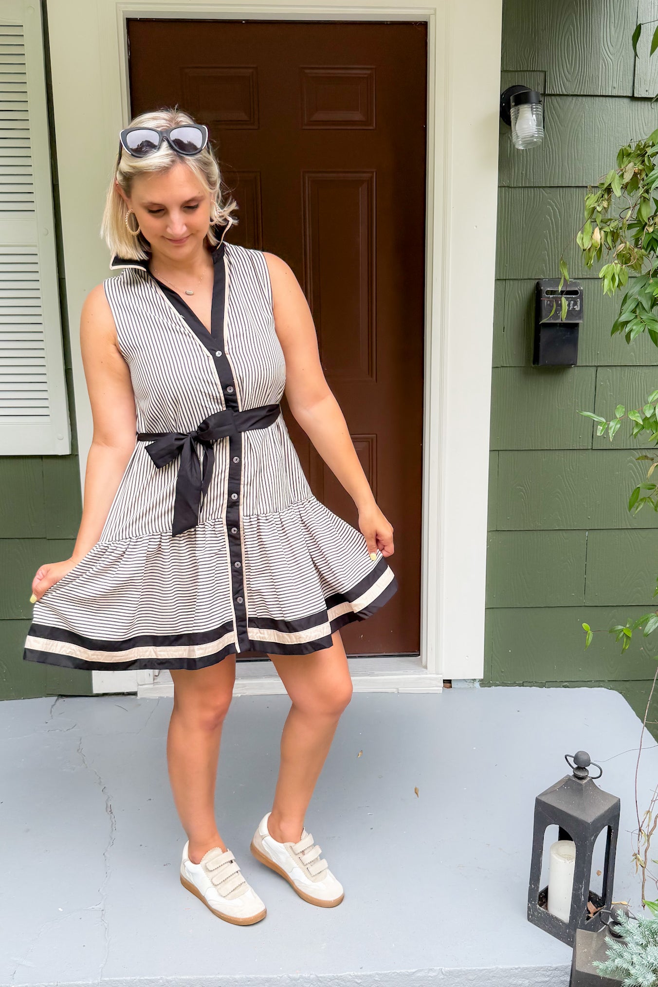 Woman in a striped dress standing on a porch