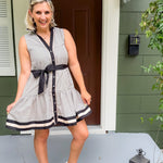 Woman in a striped dress standing outside a house
