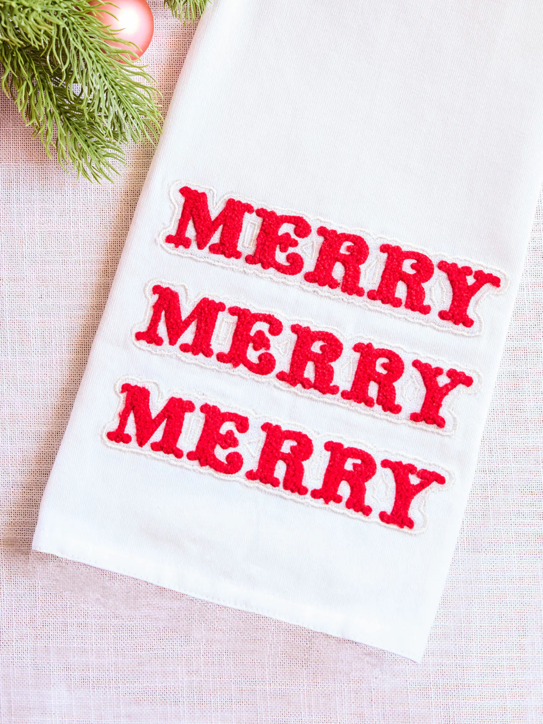White towel with red 'MERRY' text on a light background
